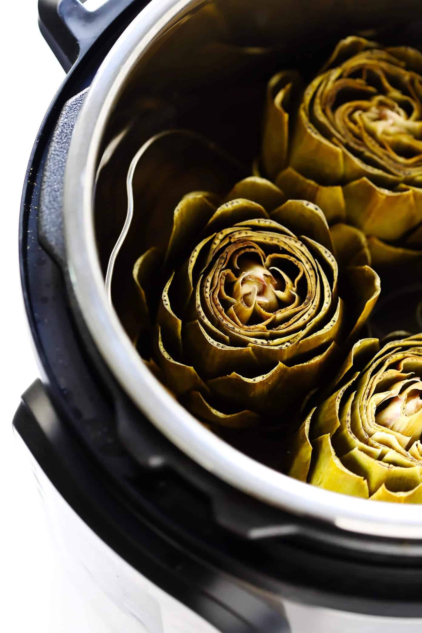 Whole trimmed artichokes shown in Instant Pot.