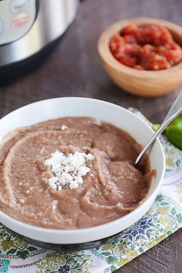 Pressure Cooker Refried Beans from Mel's Kitchen Cafe shown in bowl with spoon