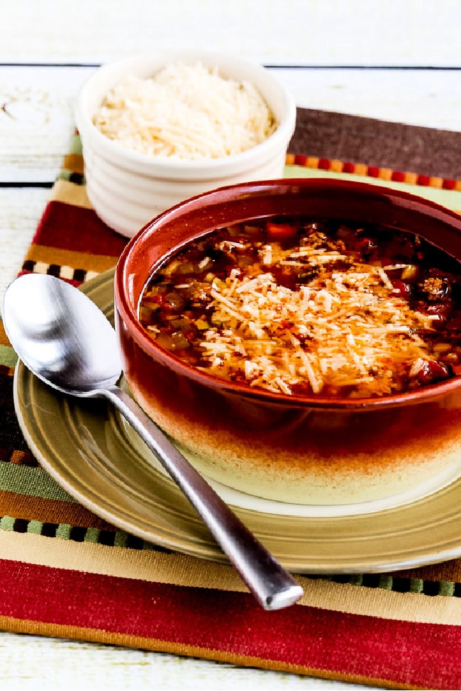 Slow Cooker Zucchini e Fagioli Soup from Kalyn's Kitchen shown in serving bowl with Parmesan in background