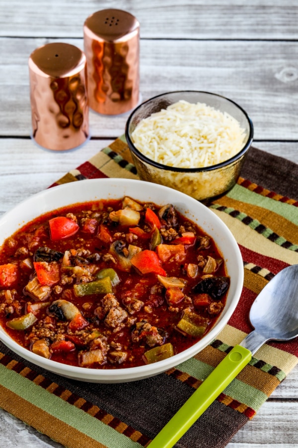 Italian Sausage Stew from Kalyn's Kitchen shown in bowl with Parmesan and salt-pepper shakers in background