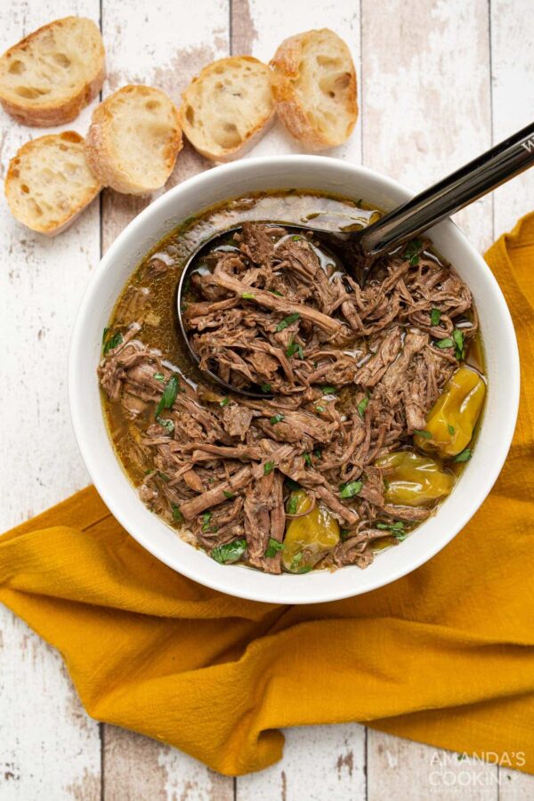 Instant Pot Mississippi Pot Roast from Amanda's Cooking shown on plate with buns in back