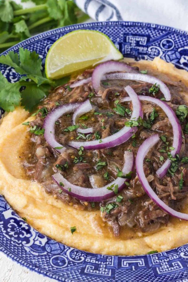 Slow Cooker Beef Chile Verde from 365 Days of Baking and More shown served on a bed of Polenta.