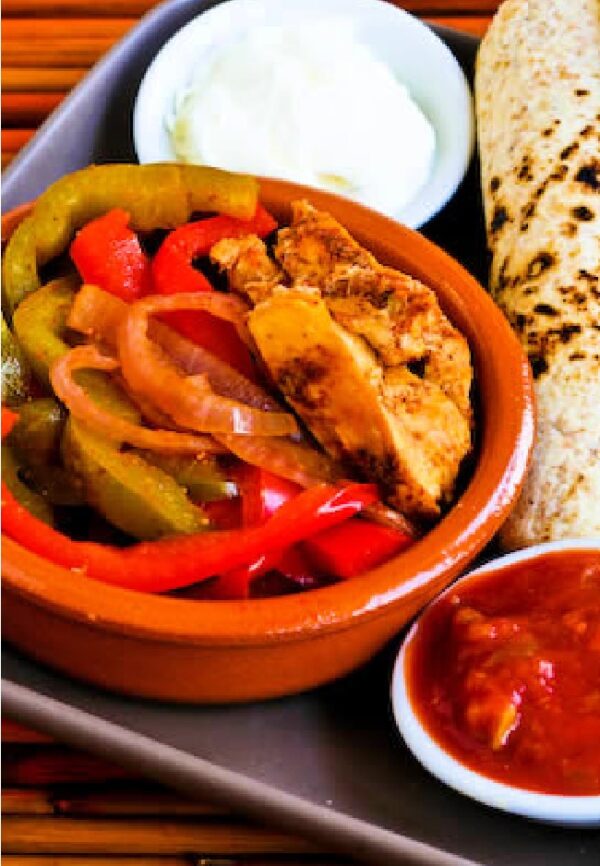 Slow Cooker Chicken Fajitas from Kalyn's Kitchen shown on serving plate with tortillas, sour cream, and salsa.